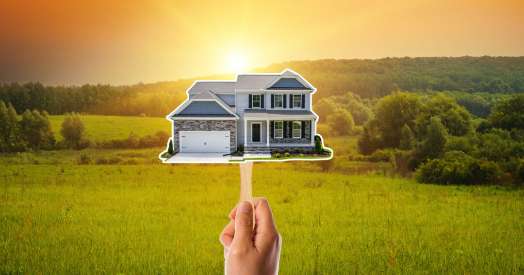 Hand holding cutout fan of a home for build on your lot